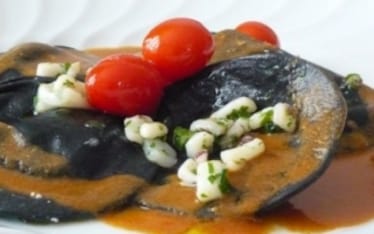 Ravioli neri di ricotta con ragù di calamari, pomodorini e bisque di gamberi