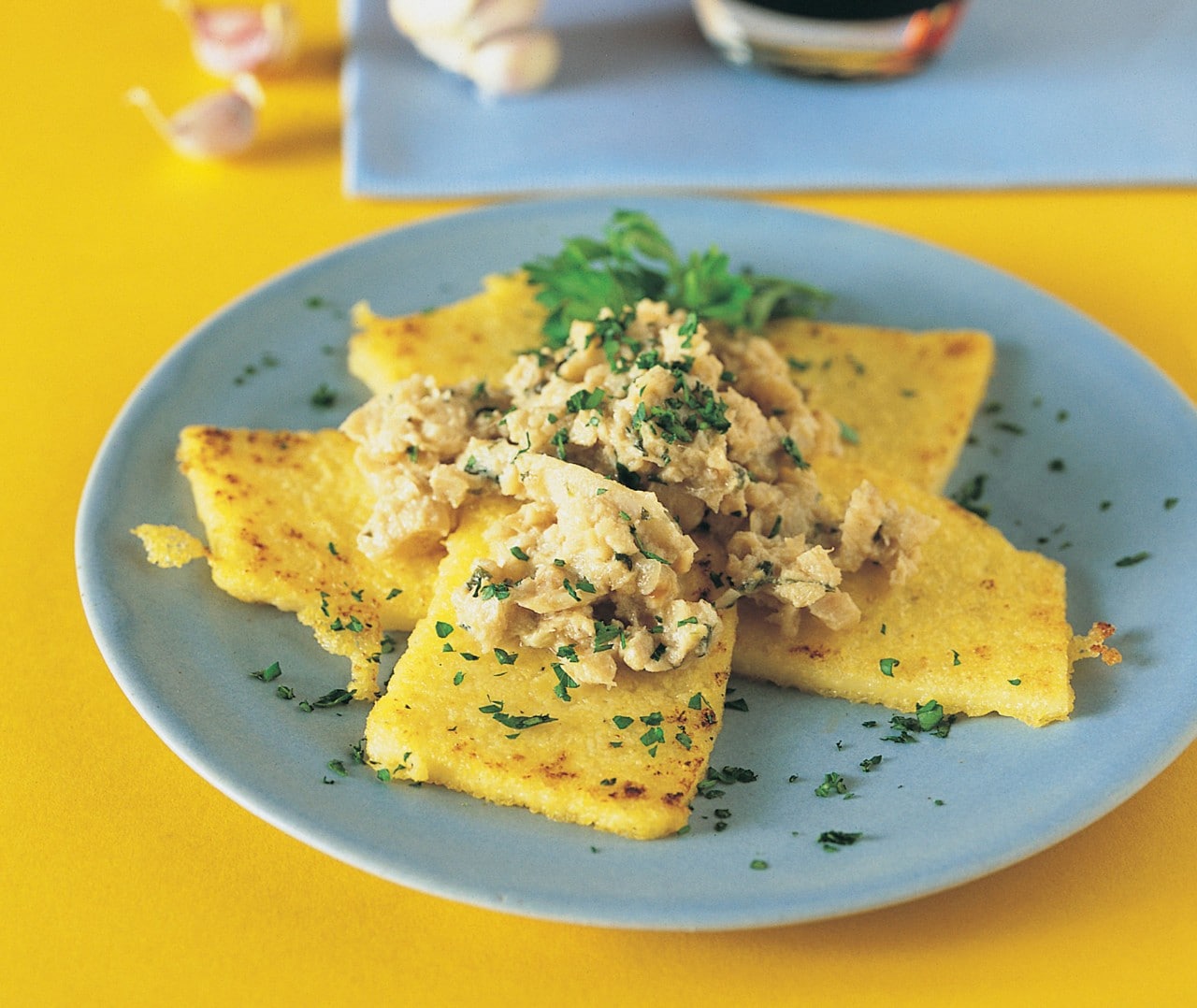 Nasello al latte con cipolle e crostoni di polenta ricetta