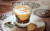 Bicchiere con cioccolato, caco, panna e amaretto