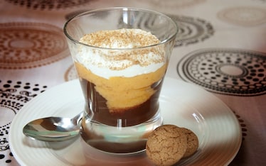 Bicchiere con cioccolato, caco, panna e amaretto
