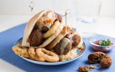 Panino con falafel, anelli di cipolla e pomodori fritti