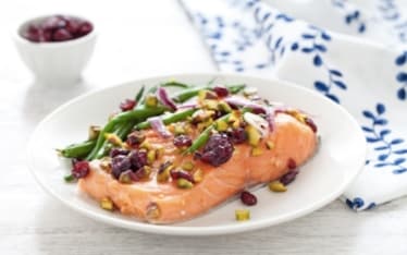 Filetto di salmone al cartoccio con fagiolini, mirtilli rossi e pistacchi