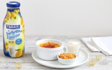 Crème brûlée alla vaniglia con pesche caramellate, crumble alle mandorle e sorbetto al limone