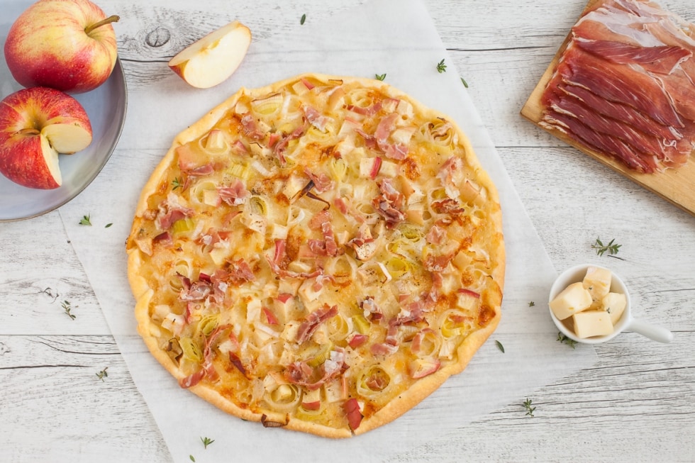 Tarte flambée al formaggio con speck, porri e mele  ricetta