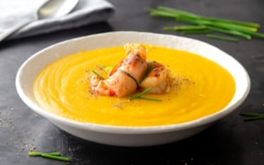 Vellutata di patate allo zafferano con gamberoni bardati