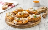 Crostini di pane integrale con crema di carote, merluzzo e mandorle a lamelle 