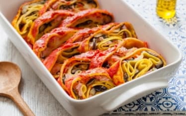 Rotolo di pasta all'uovo ripieno con melanzane, prosciutto cotto e scamorza